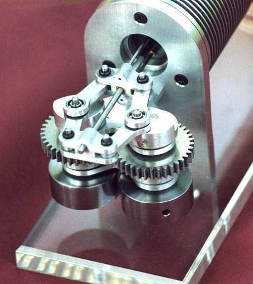 Silver metal gear mechanism on clear acrylic base with interlocking teeth.