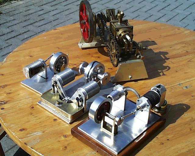 Small metal devices with coils and wires displayed on wood.