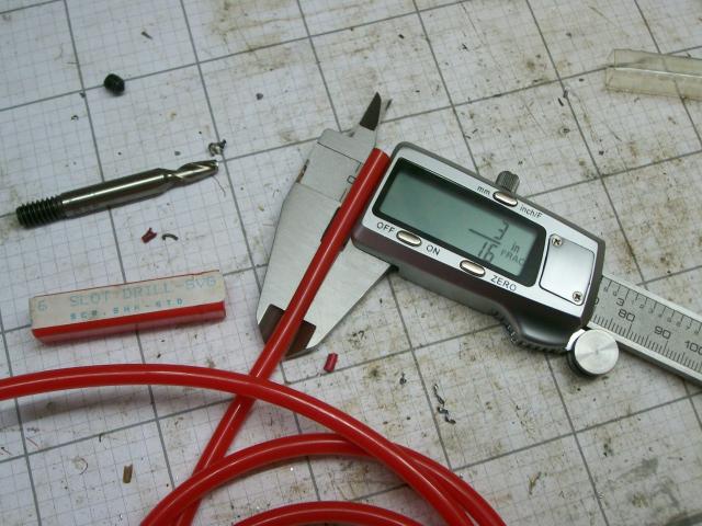 Precision measurement tools: calipers, micrometer, digital caliper on a cutting mat.