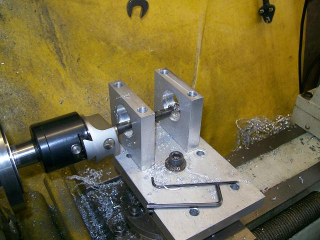 A metalworking lathe with tools and workpiece on its bed.