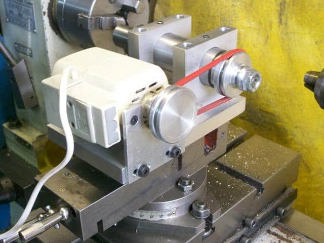 Industrial lathe with metal components, tools, and machinery.