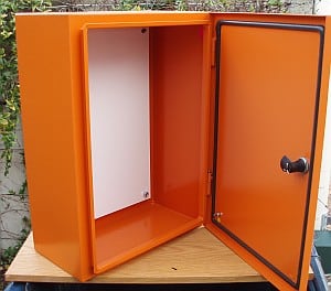 Rectangular metal storage box with open door on wooden surface.