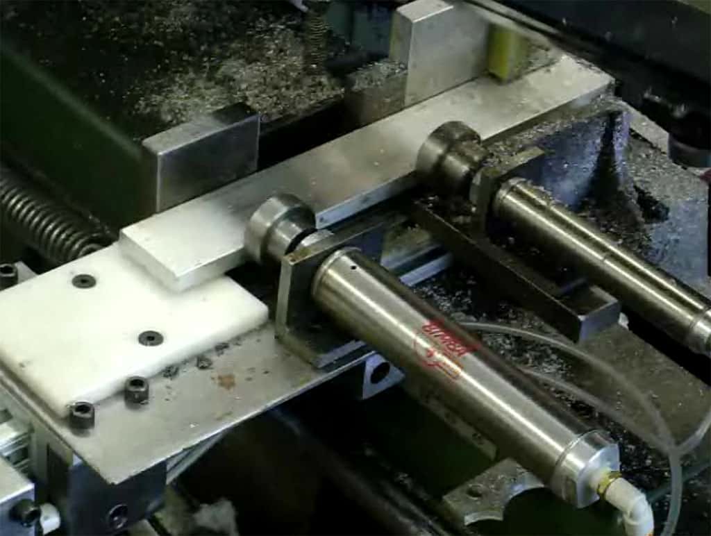 Silver industrial machine part with red logo and text.