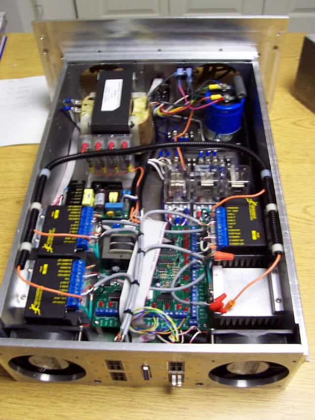 An open silver metal box containing densely packed electronic components.