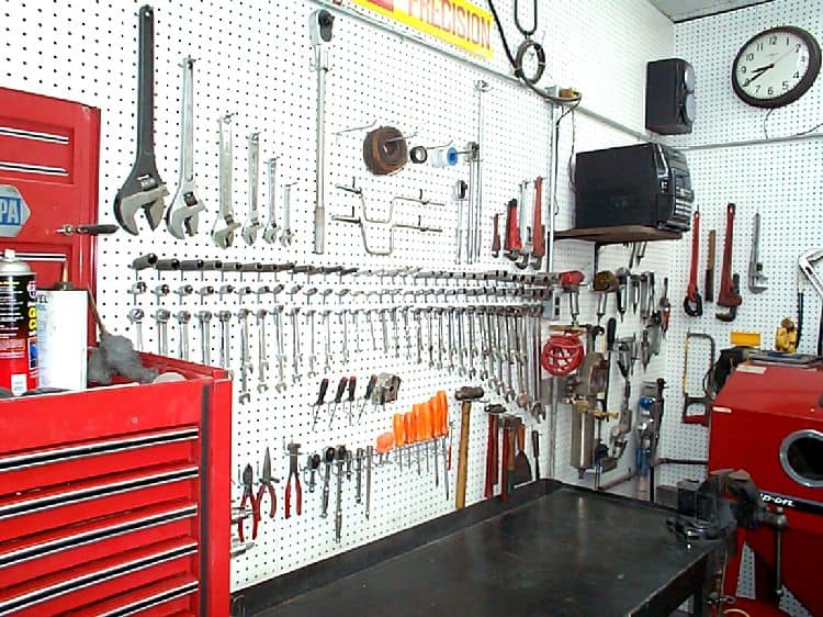 Well-organized workshop with tools on pegboards and metrology equipment.