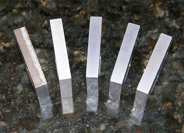 Metal files arranged in a fan shape on dark granite.