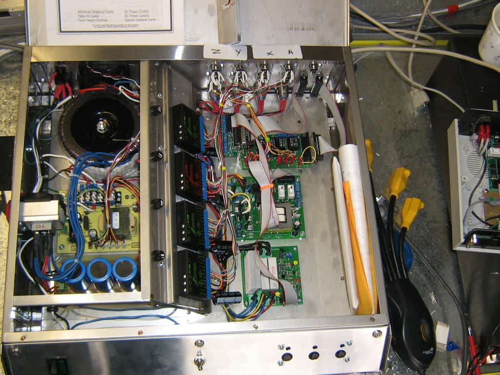 Complex electronic circuitry in a custom-built metal box with densely packed wires and various components.