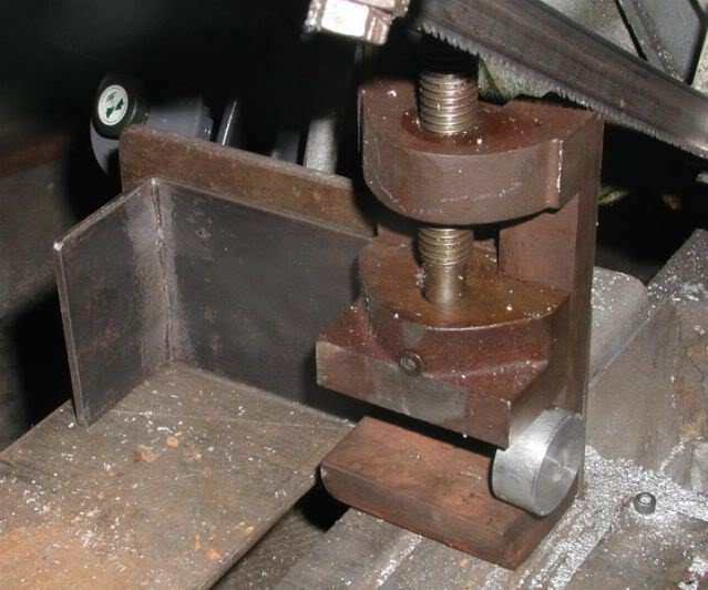 Metal vise with screw attachment on a corroded metal table.