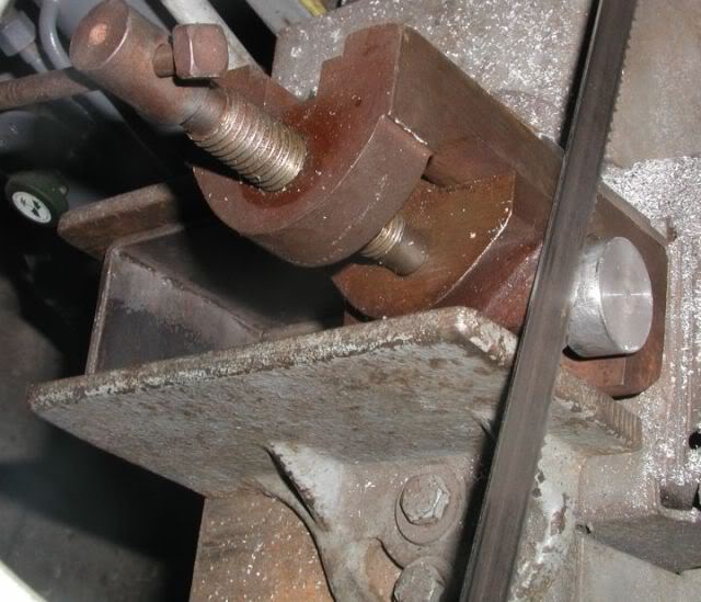 Metal vise on a bolted base for manufacturing or machining processes.