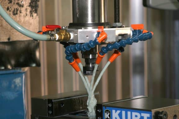 Metal fabrication tool in workshop with CNC machine and tools.