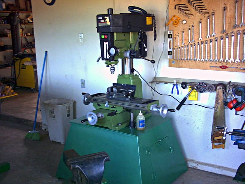 Well-equipped workshop with milling machine, drill press, band saw, and workbenches.