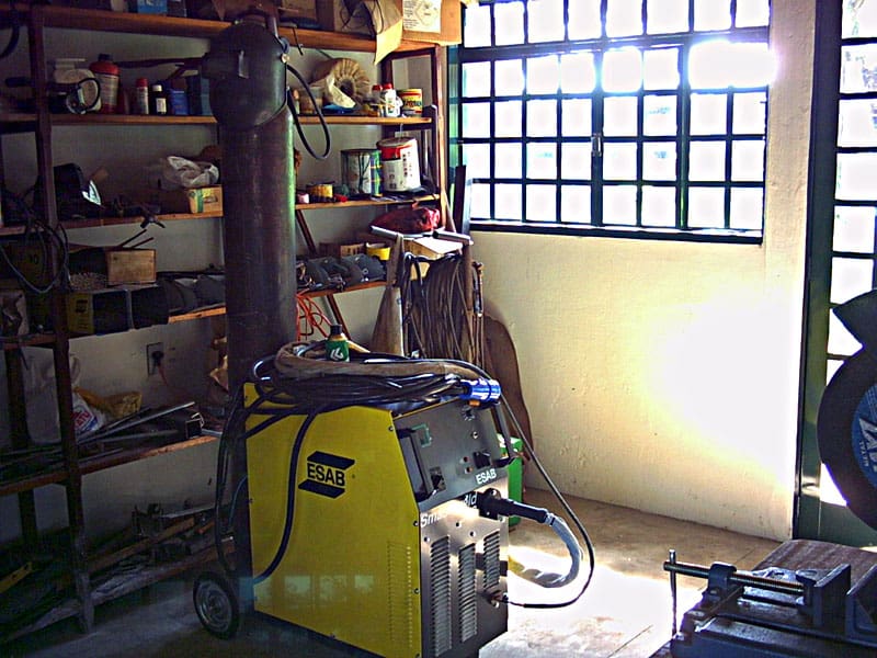 Welding machine in a workshop setting with ESAB welder and various tools and equipment.