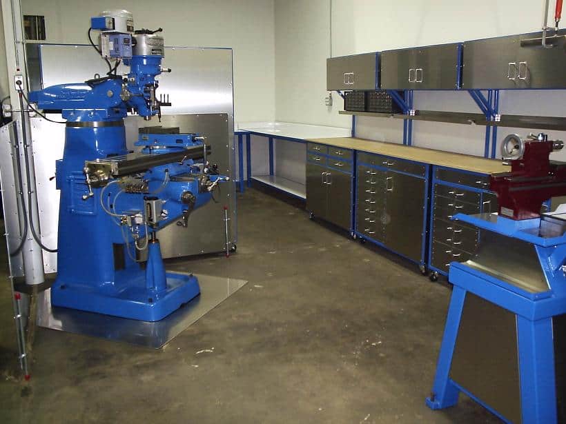 A well-equipped workshop with multiple large blue machines and organizational storage.