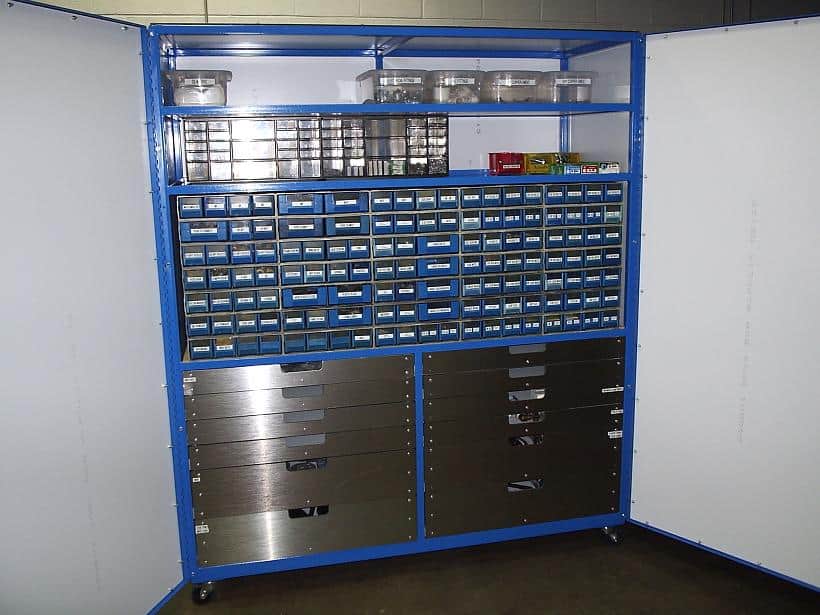 Large blue cabinet with multiple drawers and shelves, metal frame, and open shelving, likely used in a workshop or machine shop.