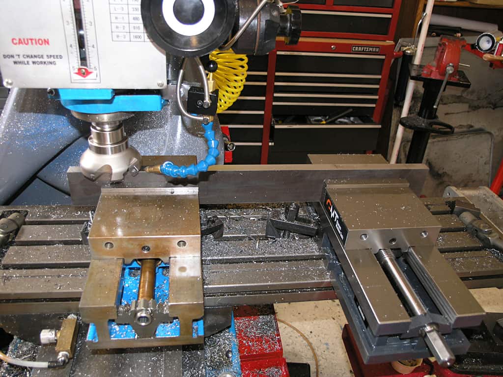 Milling machine in operation with cutting tool and various equipment.