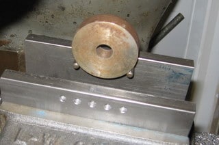 Metal workpiece held in place by soft jaw pin.