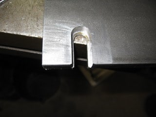 Silver metal part with small lip/tab.