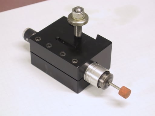 Small black metal tool with silver knob and orange tip.