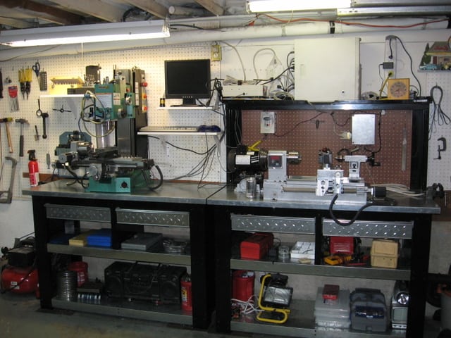 Well-organized metal workshop with various tools and machinery.
