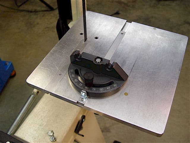 Metal table with miter gauge attached.