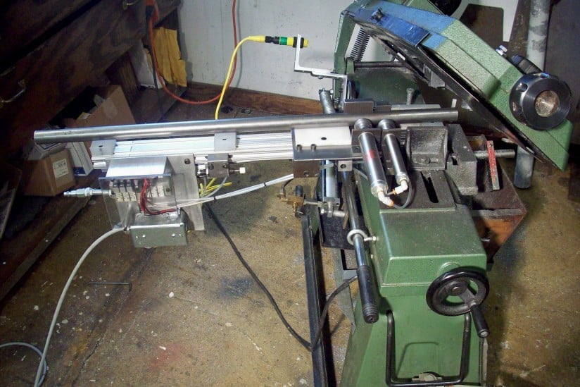 Metal bar feeder with components.
