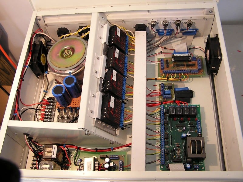 Electrical control box interior with complex wiring, circuit boards, and electronic components.