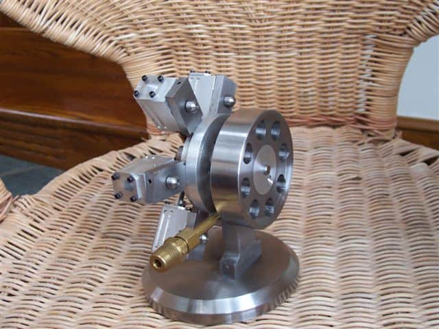 Silver metal component on wicker surface with brass tube attachment.