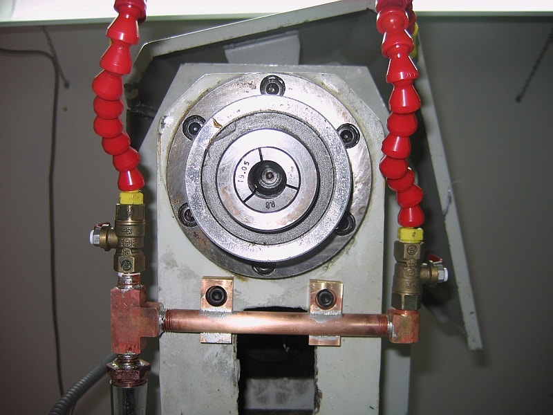 Metal pipe with red hose clamps and copper piping.