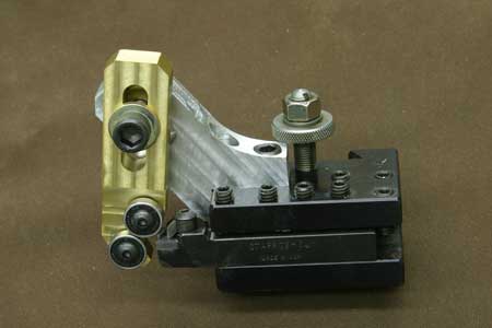 Small metal component with screw and holes.