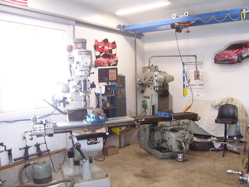 Milling machines and tools in a well-lit workshop.