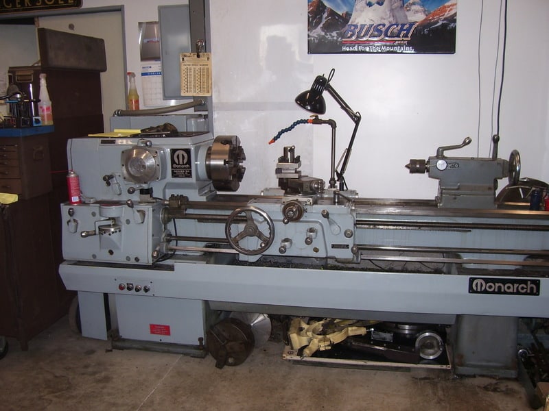 Large gray Monarch metal lathe in a machine shop workshop.