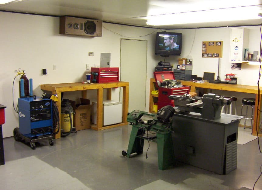 Well-organized workshop with lathe, drill press, and welding machine.