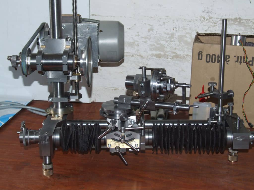 Industrial machine tool on a wooden workbench, surrounded by a white wall.