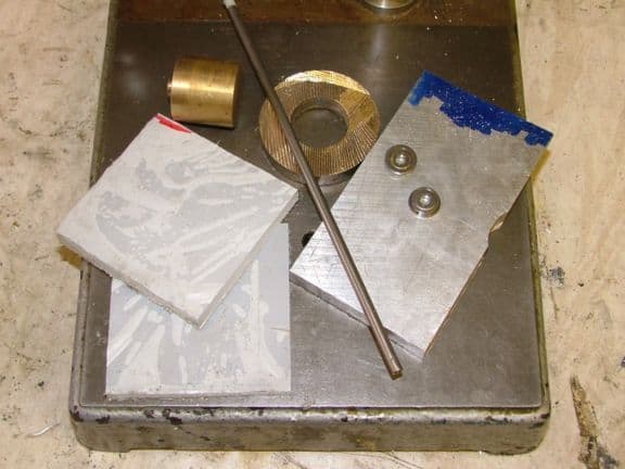 Metalworking tools and materials: brass, aluminum, steel components.