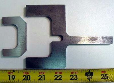 Metal part with T-cross section and two rectangular holes.