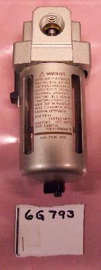 A silver cylindrical metal filter with black text warning label.