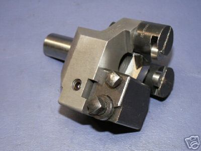 Metallic component with cylindrical protrusion and threaded hole against a gray background.