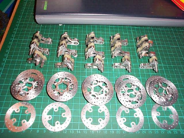 Metal parts arranged on a green cutting mat.