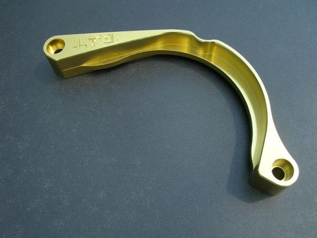Brass-colored metal component with engraved "EAT" logo and two holes.