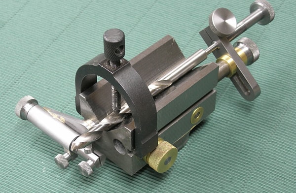 Drill sharpening tool on green surface.