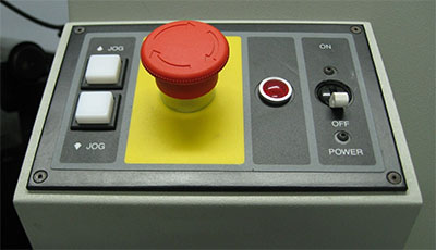 Industrial control panel with red and white buttons.