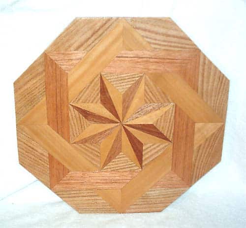 Wooden octagonal medallion with star-shaped pattern in centre.