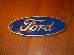 Blue oval with gold cursive text: "Ford".
