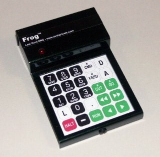 A black rectangular CNC machine control panel with white keypad and red button.