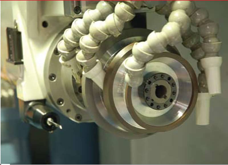 Metal gang tool with circular component, multiple holes, and mechanical parts, made from metal.