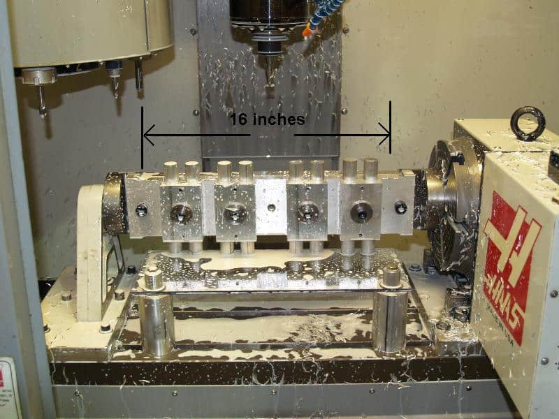 A 4-axis CNC milling machine with spindle, gantry, and table in operation.