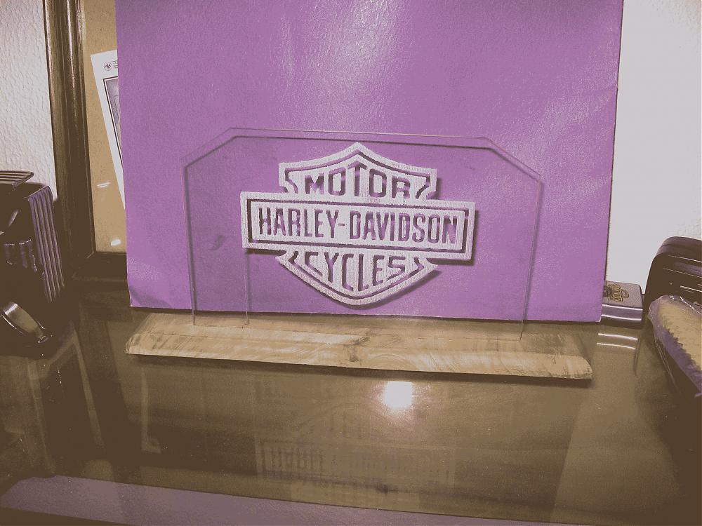 Glass Harley-Davidson logo on a wooden base.