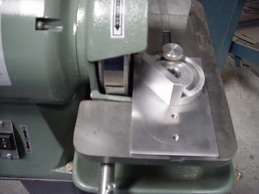 Green grinder with silver miter attachment.