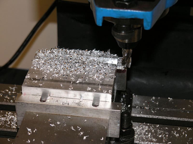 Machining a metal workpiece with milling machine, first chips appearing.