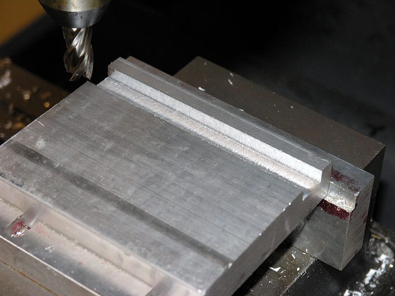 A close-up view of machined aluminum with flat surface and parallel grooves.
